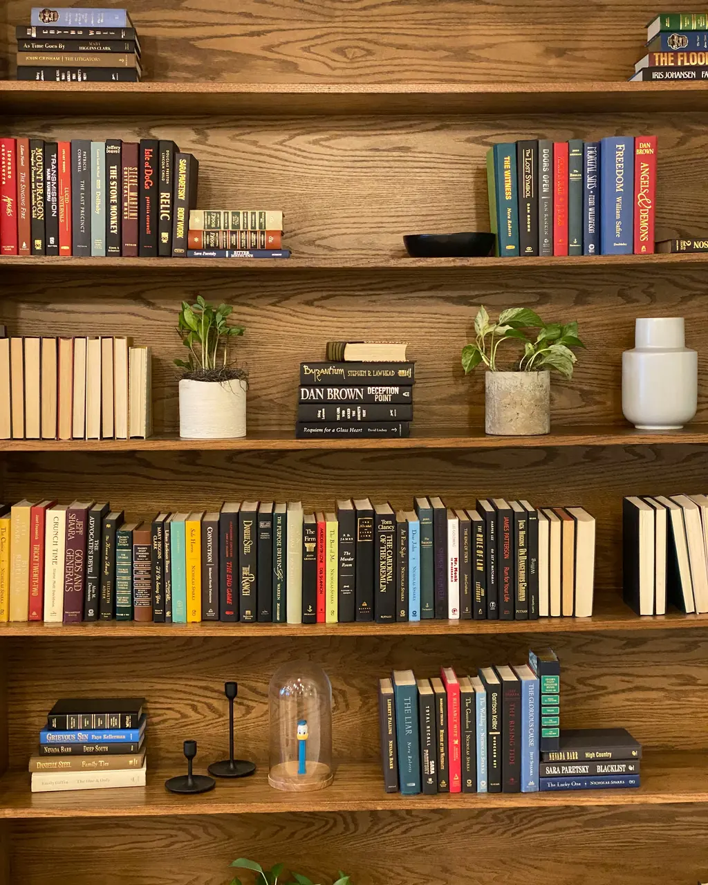 Dark oak shelves filled with books, close up.