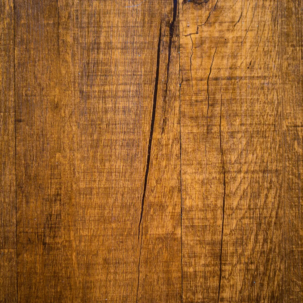 Close-up of a golden oak board with open grain and a fine crack.